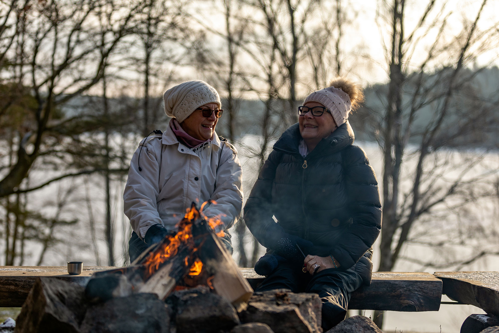 Senior ladies sitting by a bonfire