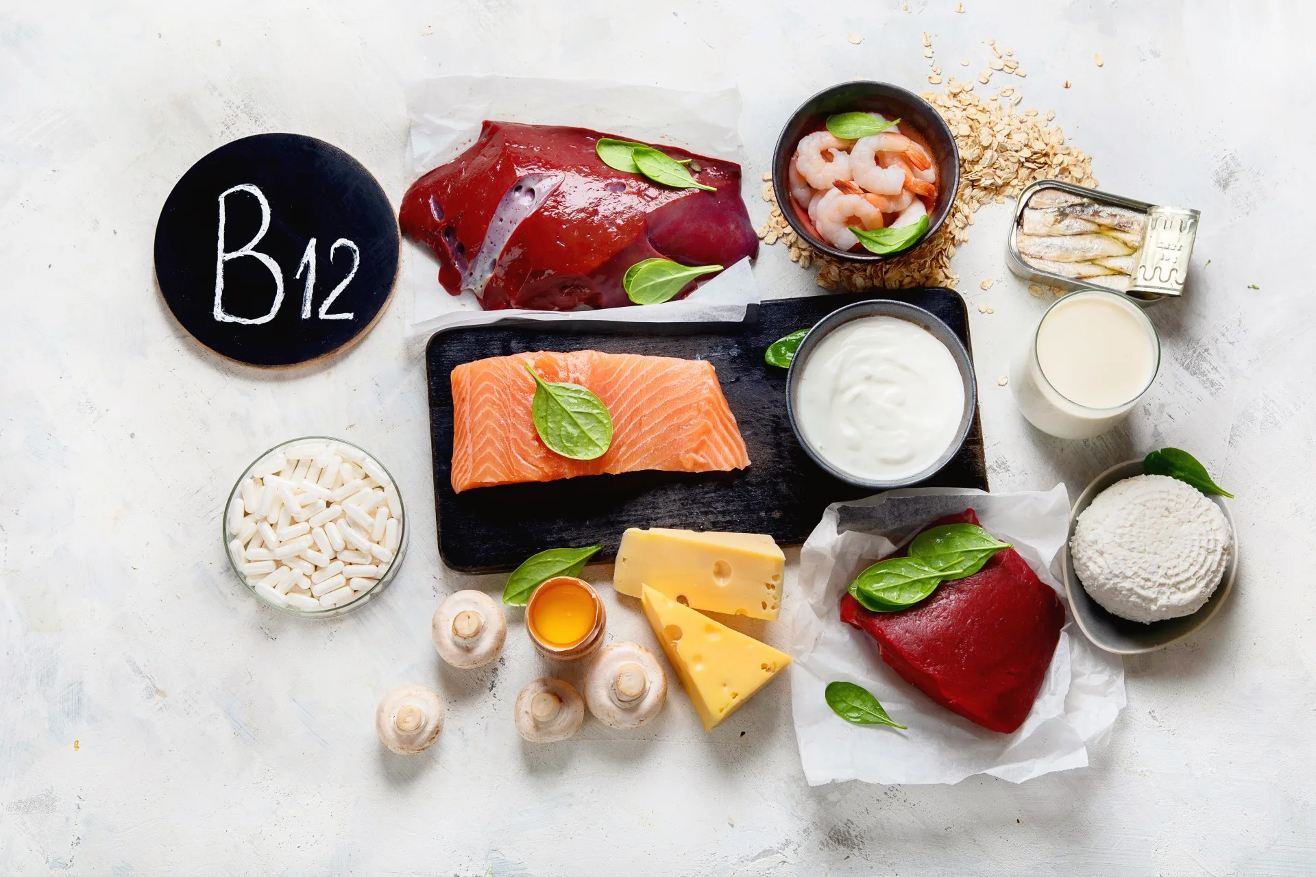 Foods with vitamin B12 displayed on a table including salmon, legumes, eggs, cheese